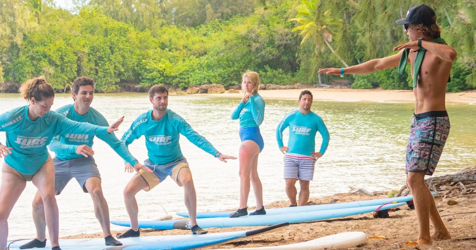 An instructor running a land lesson for a group on the beach at Turtle Bay
